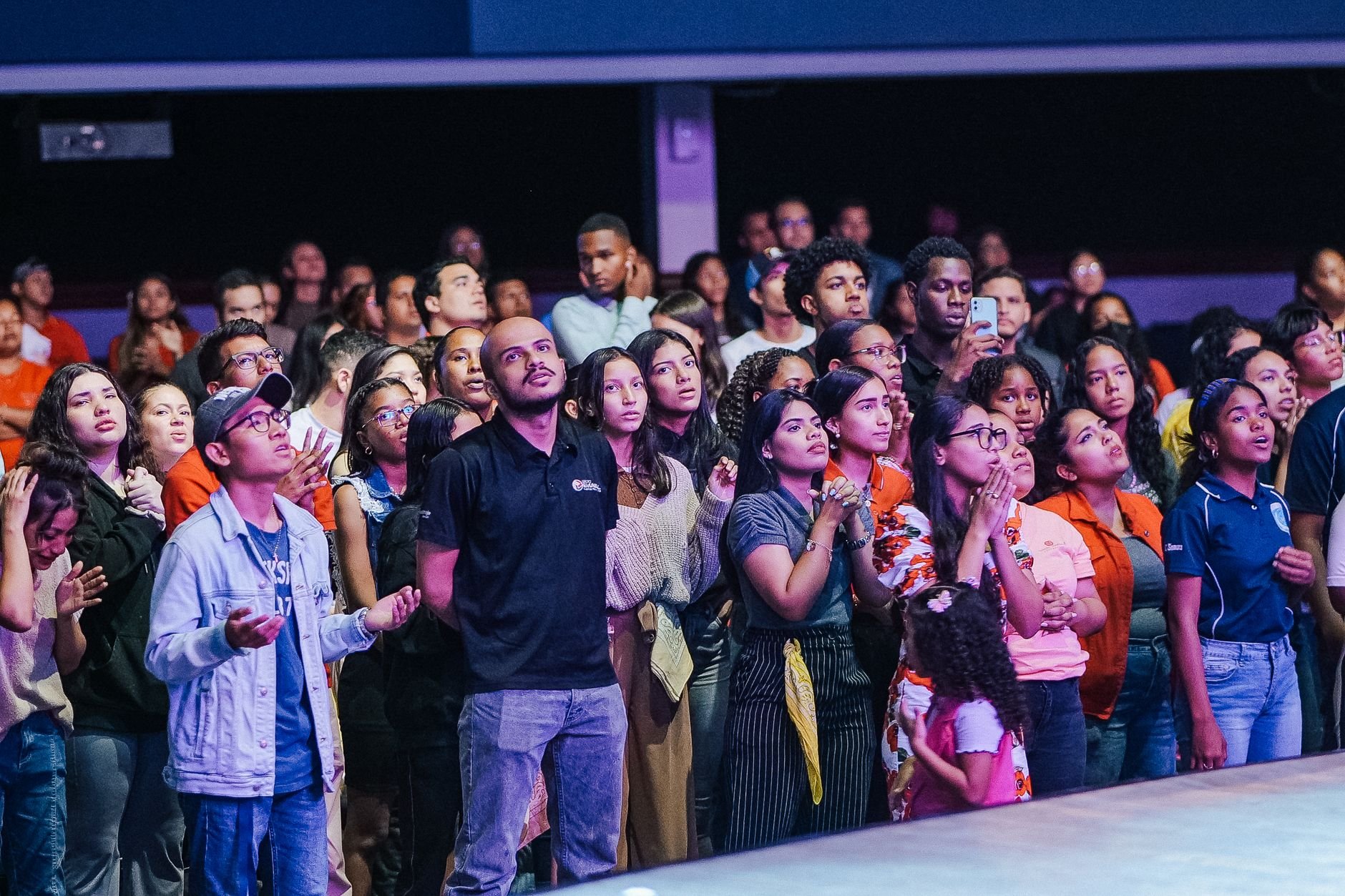 A diverse group of people gathered in a church for a religious worship service